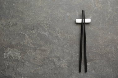 Gri masada dinlenen bir çift siyah çubuk, üst manzara. Metin için boşluk