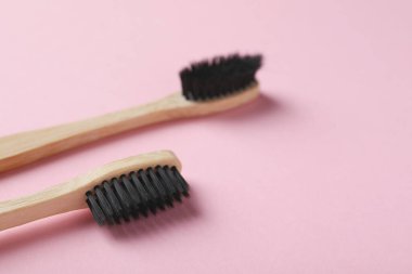 Pembe arka planda iki bambu diş fırçası, yakın plan. Metin için boşluk
