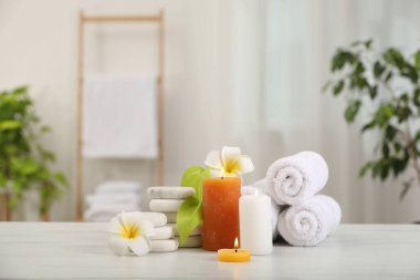 Beyaz mermer masa içerisindeki farklı spa ürünleri ve plumeria çiçekleriyle kompozisyon, metin için boşluk