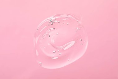 Açık pembe arka planda temizleme jeli örneği, üst manzara. Kozmetik ürünü