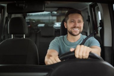 Radyo dinliyordum. Arabadaki müzikten hoşlanan yakışıklı adam, ön camdan bakıyor.