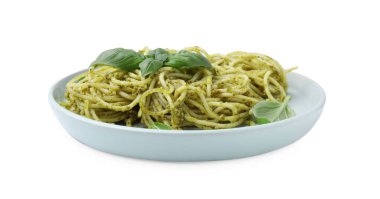 Pesto soslu bir tabak lezzetli makarna ve beyaz üzerine izole edilmiş fesleğen
