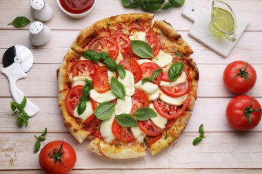 Domatesli lezzetli Caprese pizzası, mozzarella ve fesleğen açık ahşap masa, düz uzanma