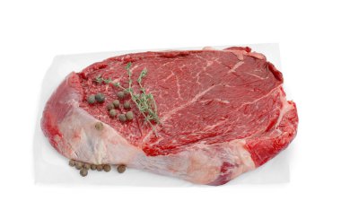 Bir parça çiğ et, karabiber ve kekik beyaz üzerine izole edilmiş.