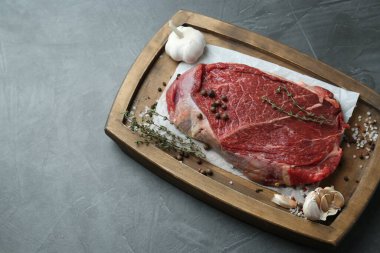 Üzerinde çiğ et, sarımsak ve kekik olan ahşap tepsi. Metin için boşluk