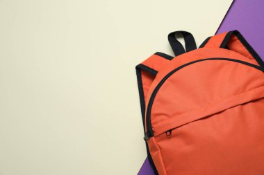 Renkli arka planda turuncu sırt çantası, üst manzara. Metin için boşluk
