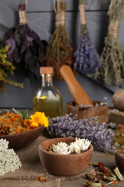 Many different dry herbs on wooden table