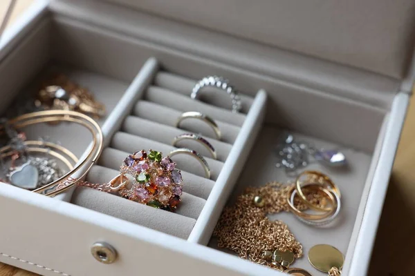 Jewelry box with many different accessories on table, closeup