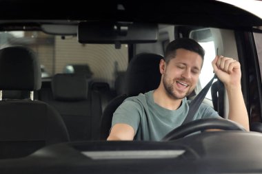 Radyo dinliyordum. Arabadaki müzikten hoşlanan yakışıklı adam, ön camdan bakıyor.