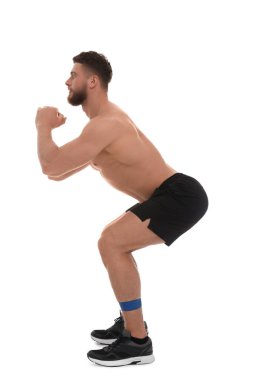 Young man exercising with elastic resistance band on white background clipart