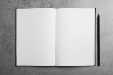 Gri masadaki düz defter ve kalemi aç