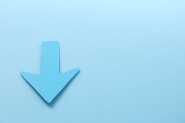 Açık mavi arkaplanda bir kağıt ok, yukarıda. Metin için boşluk