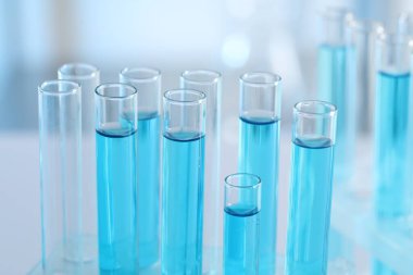 Laboratuvarda açık mavi sıvıyla test tüpleri, yakın plan.