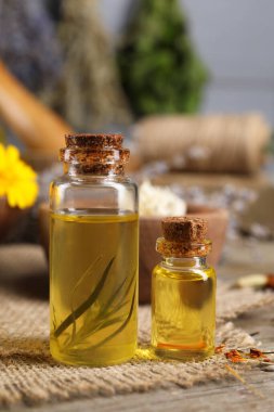 Gerekli yağlar ve ahşap masada farklı otlar.