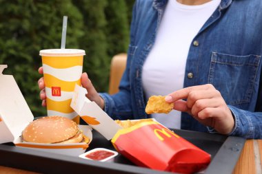 Lviv, Ukrayna - 9 Ekim 2023: Açık havada McDonald 's menüsü olan kadın, yakın plan