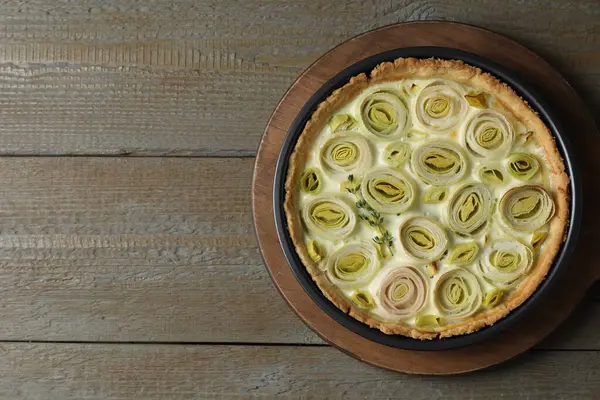 Tasty leek pie on wooden table, top view. Space for text