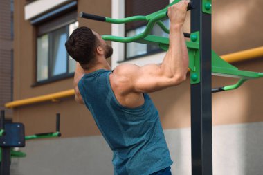 Spor salonunda barfiks çeken bir adam.
