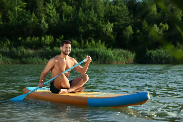 Man paddle boarding on SUP board in river