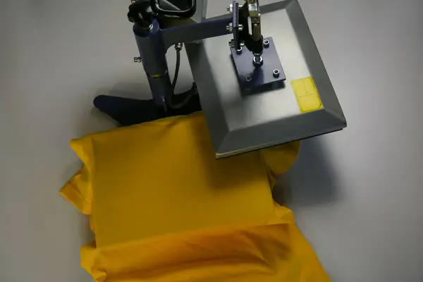 Printing logo. Heat press with t-shirt on white table, above view