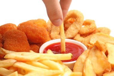 Beyaz arka planda lezzetli ketçapla patates kızartmasını kaseye daldıran kadın, yakın plan.