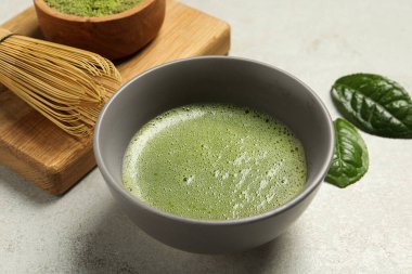 Açık gri masada taze yeşil kibrit çayı ve bambu çırpısı, yakın plan.