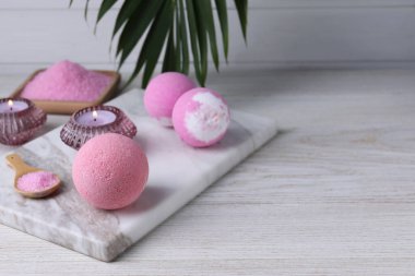 Beyaz ahşap masa üzerinde aromatik banyo bombaları olan güzel bir kompozisyon.