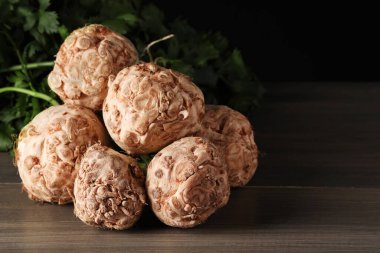 Ahşap masada taze çiğ kereviz kökleri, yakın plan.