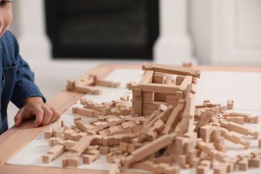 Küçük çocuk masa içinde tahta bloklarla oynuyor, yakın plan. Çocuk oyuncağı