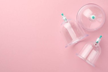 Pembe arka planda plastik bardaklar, metin için yeri olan düz yataklar. Fincan terapisi.