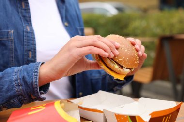 Lviv, Ukrayna - 9 Ekim 2023: McDonald 's burgerli kadın açık havada, yakın plan