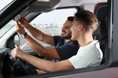 Ehliyet kursu. Otoparkta sürüş eğitmeniyle ders sırasında mutlu öğrenci.