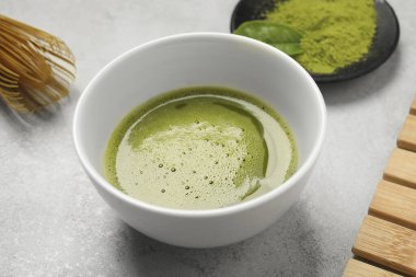 Açık gri masada taze kibrit çayı, yakın plan.