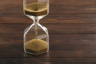 Ahşap masada kum akan kum saati, yakın plan. Metin için boşluk