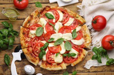 Domatesli lezzetli Caprese pizzası, ahşap masada mozzarella ve fesleğen.