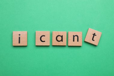 Motivasyon konsepti. I Can 'den I Can' e geçiş cümlesi yeşil arkaplandaki T harfiyle ahşap kareyi kaldırarak yapılabilir.