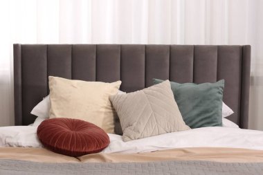 Yumuşak yastıkları ve odada yorganı olan büyük, rahat bir yatak. Ev tekstili