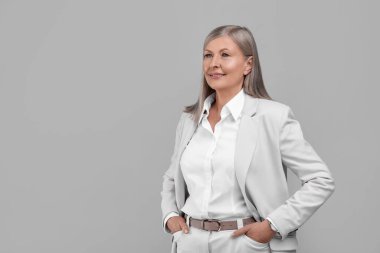 Gri arka planda güzel, yaşlı bir kadının portresi. Metin için boşluk