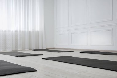 Egzersiz paspasları olan geniş bir yoga stüdyosu. Metin için boşluk