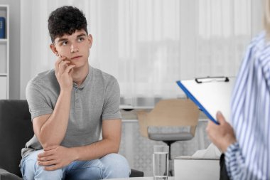 Ofiste genç bir çocukla çalışan bir psikolog. Gençlik sorunları