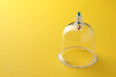 Sarı arka planda plastik bardak, mesaj için boşluk. Fincan terapisi.