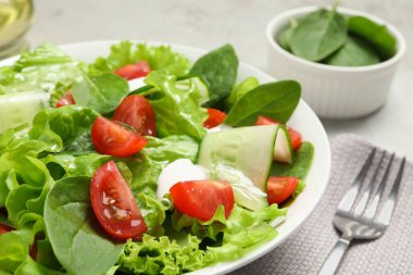 Açık gri masada servis edilen lezzetli sebze salatası, yakın plan.