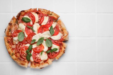 Domatesli lezzetli Caprese pizzası, beyaz fayanslı fesleğen ve mozzarella, üst manzara. Metin için boşluk