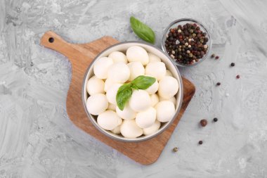 Lezzetli mozarella topları ve fesleğen yaprakları gri masada, düz yatıyordu.