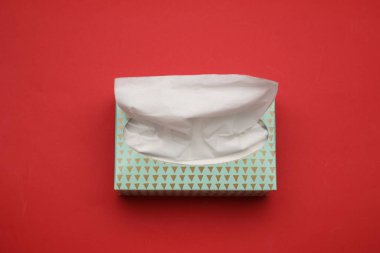 Kırmızı arkaplanda kağıt mendil kutusu, yukarıda görünüm