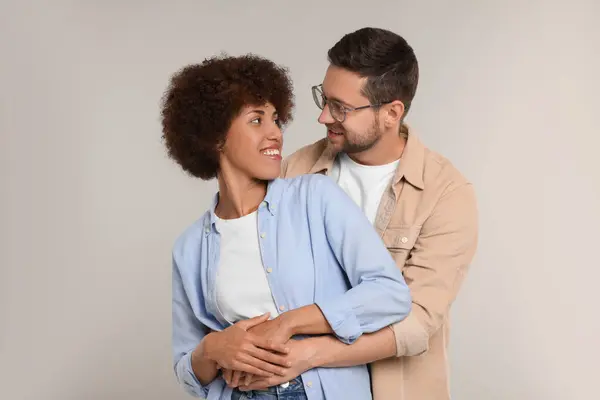 stock image International dating. Happy couple hugging on light grey background