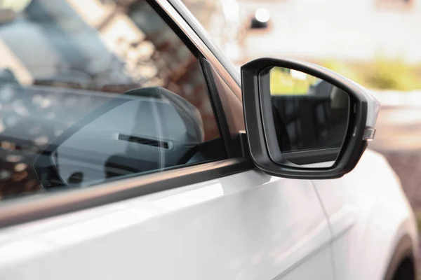 Side view mirror of modern car on blurred background, closeup