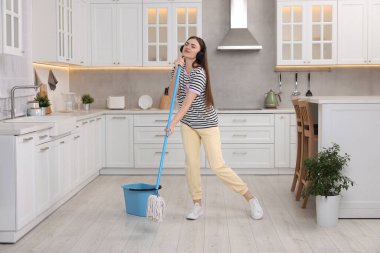 Temizliğin tadını çıkarıyorum. Kulaklıklı kadın müzik dinliyor ve mutfakta paspas yapıyor.