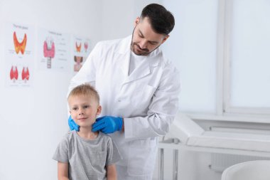 Hastanedeki çocuğun tiroid bezini inceleyen bir endokrinolog.