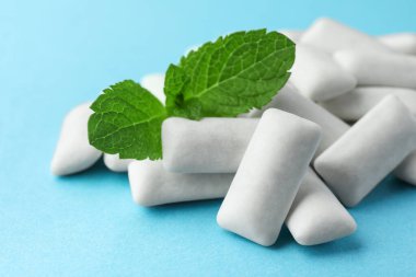 Lezzetli beyaz diş eti yığını ve açık mavi arka planda nane yaprakları, yakın plan.