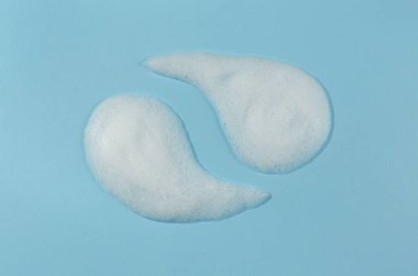 Açık mavi arkaplanda köpük örnekleri var. Kozmetik ürünü